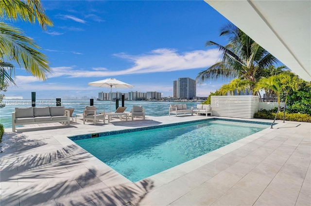 view of pool with a water view and a patio