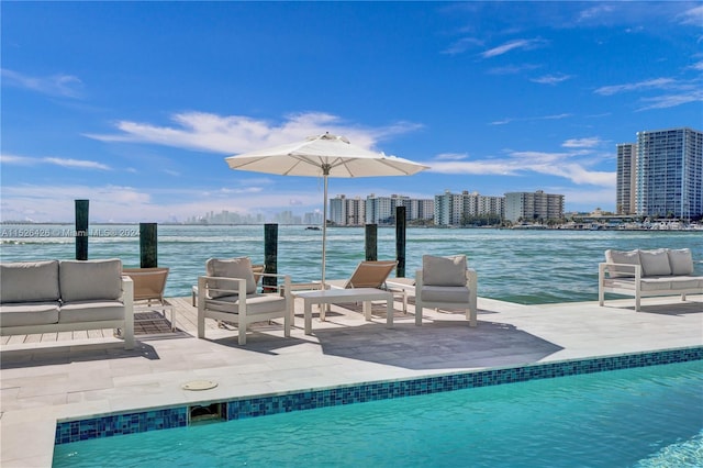 view of pool with an outdoor hangout area and a water view