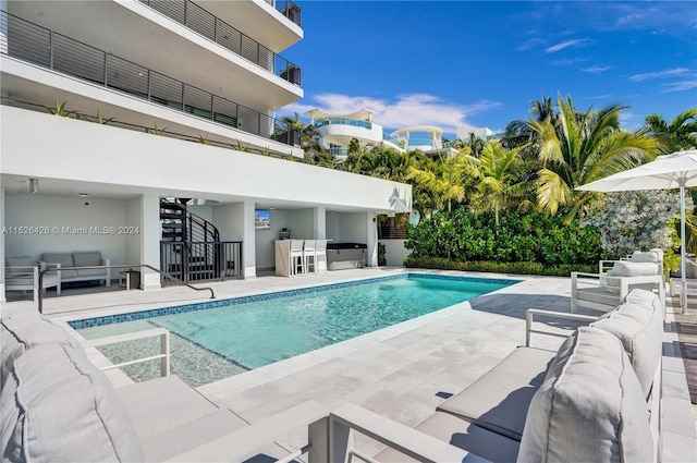 view of swimming pool featuring an outdoor living space, a patio area, and area for grilling