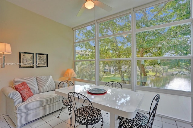 sunroom / solarium featuring plenty of natural light, ceiling fan, and a water view