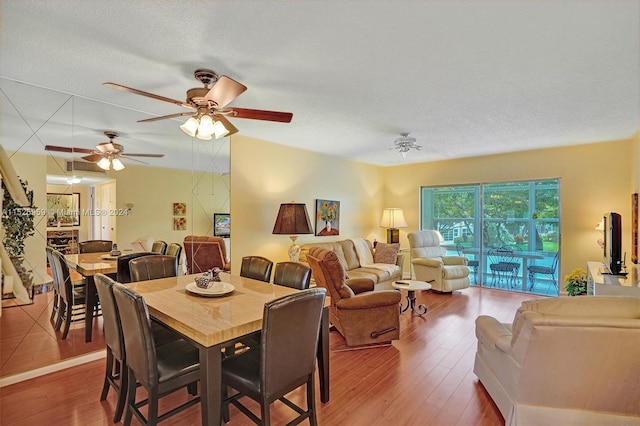 dining space with a textured ceiling, ceiling fan, and dark hardwood / wood-style flooring