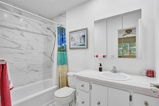 full bathroom featuring ceiling fan, shower / tub combo with curtain, vanity with extensive cabinet space, and toilet