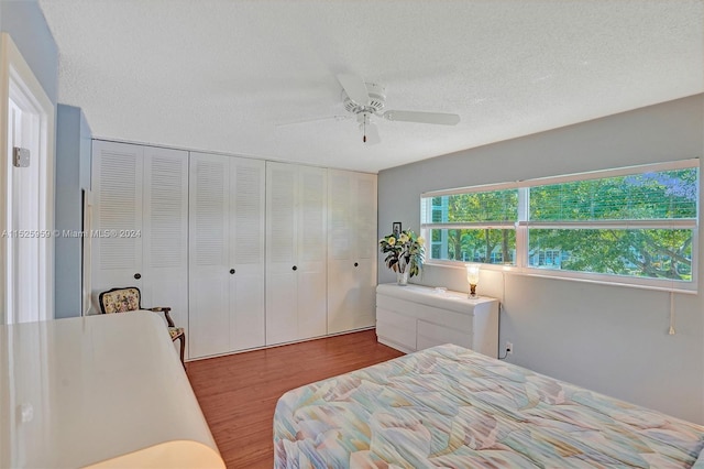 bedroom featuring a closet, hardwood / wood-style floors, a textured ceiling, and ceiling fan