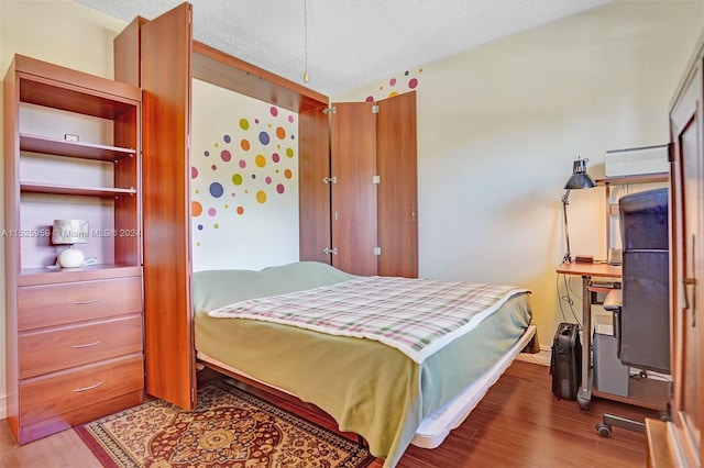 bedroom featuring a textured ceiling and hardwood / wood-style flooring