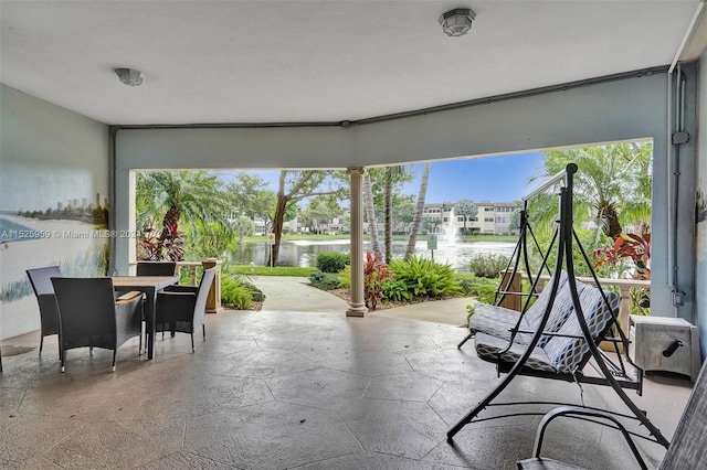 sunroom / solarium featuring a water view