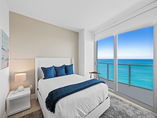 bedroom featuring a water view and access to exterior