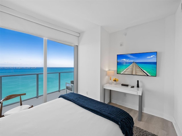 bedroom with a water view and light hardwood / wood-style flooring