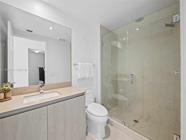 bathroom with vanity, tile flooring, a shower with shower door, and toilet