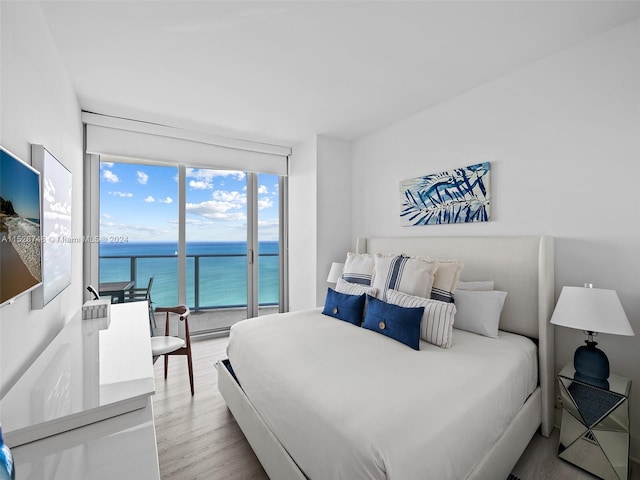 bedroom featuring a water view and light hardwood / wood-style flooring