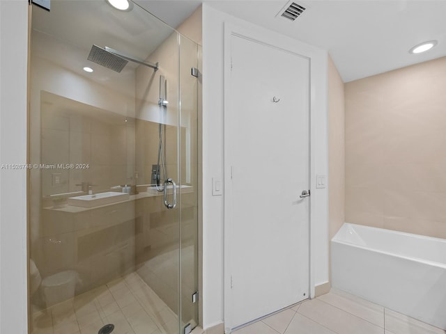 bathroom with tile flooring and separate shower and tub