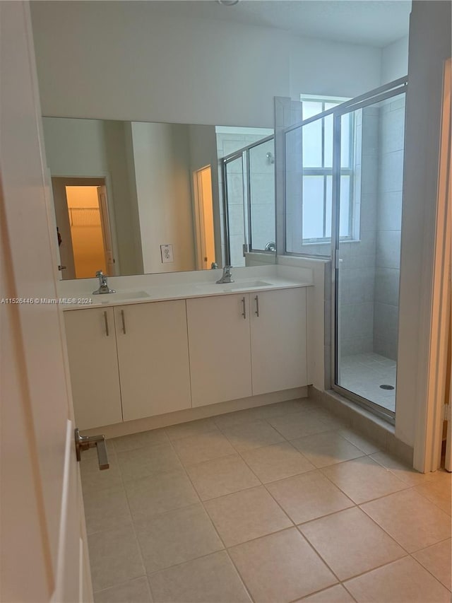 bathroom with tile patterned flooring, vanity, and an enclosed shower