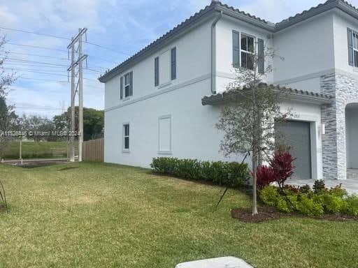 view of property exterior with a lawn and a garage