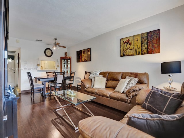 living room featuring ceiling fan and dark hardwood / wood-style flooring