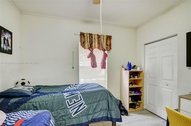 bedroom with ornamental molding, ceiling fan, a closet, and light hardwood / wood-style flooring