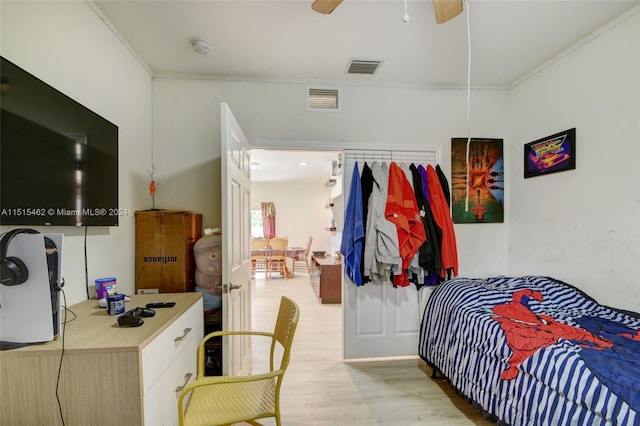 bedroom with ornamental molding, ceiling fan, and light hardwood / wood-style flooring