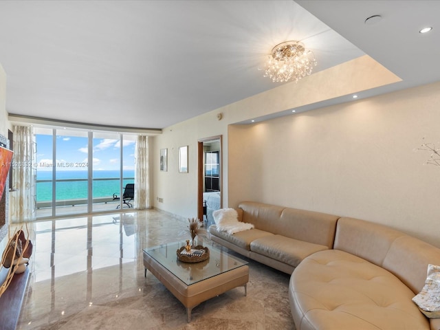 living room featuring a chandelier, expansive windows, and a water view