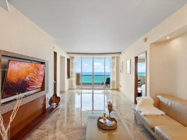 living area featuring a water view, marble finish floor, expansive windows, and baseboards