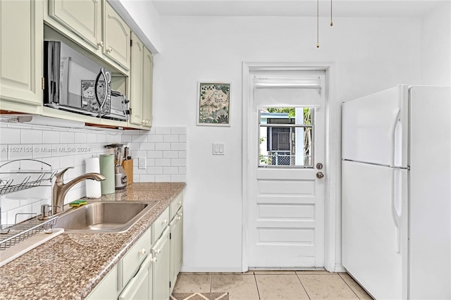 kitchen with light tile floors, tasteful backsplash, sink, and white refrigerator