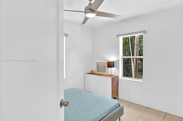 tiled bedroom featuring ceiling fan