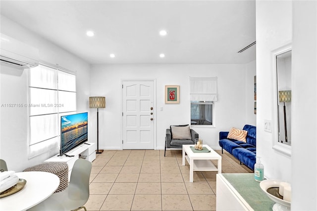 living room with light tile floors and an AC wall unit