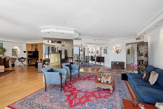 living room featuring crown molding, an inviting chandelier, and wood-type flooring