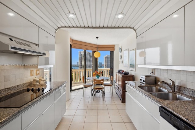 kitchen featuring decorative light fixtures, tasteful backsplash, white cabinetry, and premium range hood