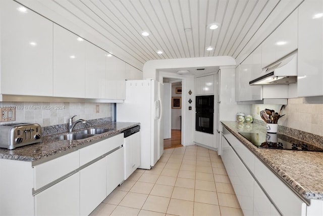 kitchen with black electric cooktop, custom exhaust hood, white cabinetry, and sink