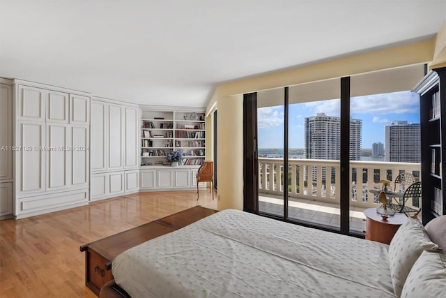 bedroom with access to exterior and light hardwood / wood-style floors