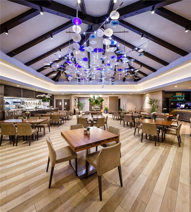 interior space featuring beam ceiling, a raised ceiling, and light hardwood / wood-style flooring