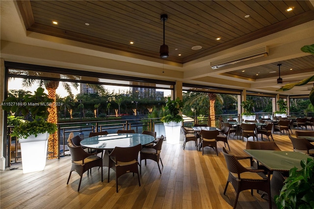 exterior space with a raised ceiling, a healthy amount of sunlight, and light wood-type flooring