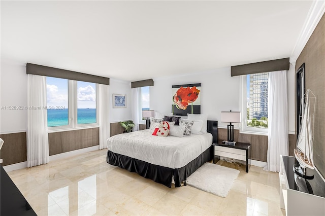 bedroom with light tile floors and a water view