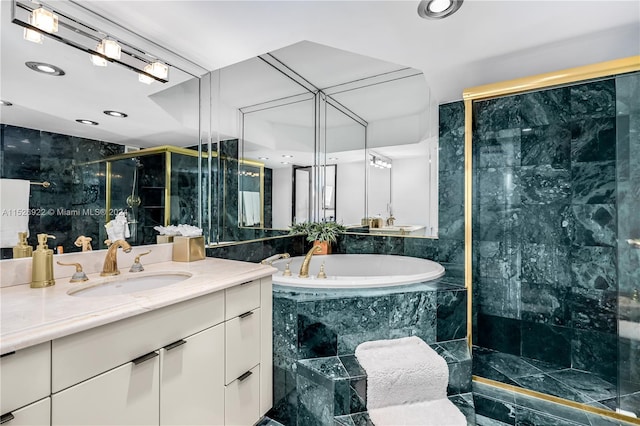 bathroom with tile flooring, independent shower and bath, oversized vanity, and tile walls