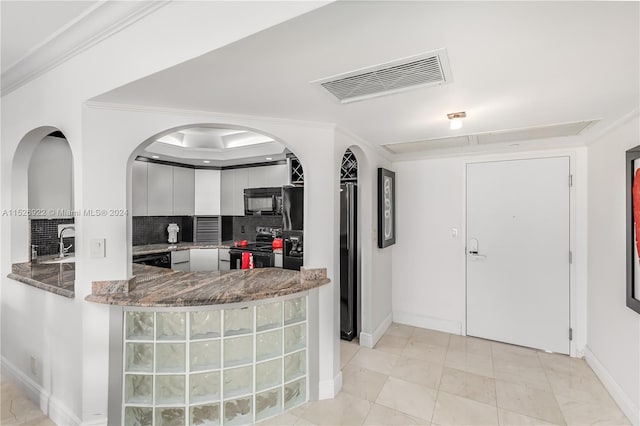 kitchen with crown molding, black appliances, white cabinetry, backsplash, and light tile floors