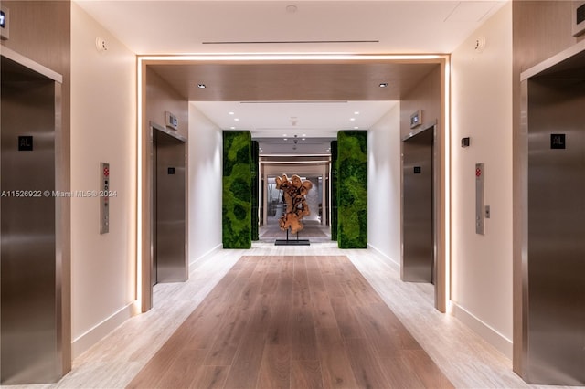 hallway featuring elevator and light hardwood / wood-style floors