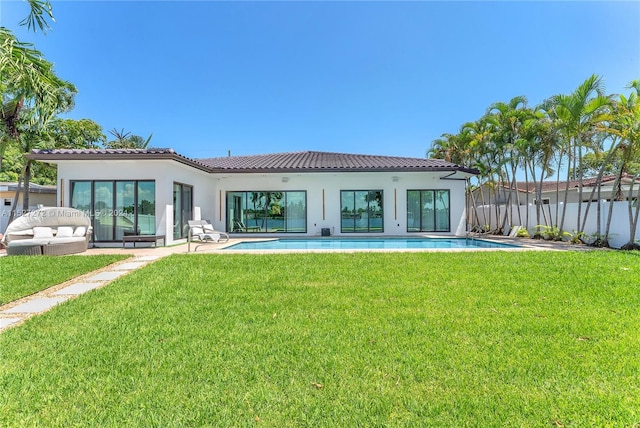 back of property with a fenced in pool, a patio area, and a yard