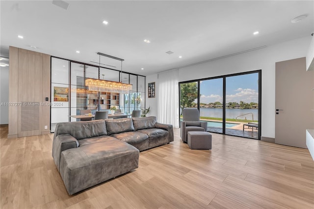 living room with a water view and light hardwood / wood-style flooring