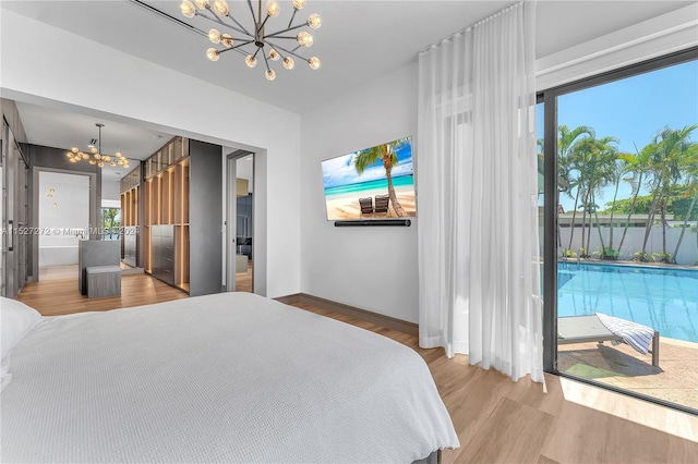 bedroom featuring access to exterior, a notable chandelier, and light hardwood / wood-style flooring