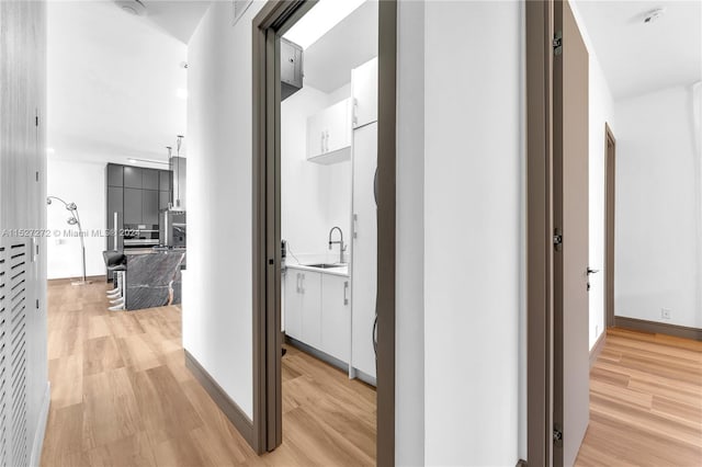 hall featuring sink and light wood-type flooring