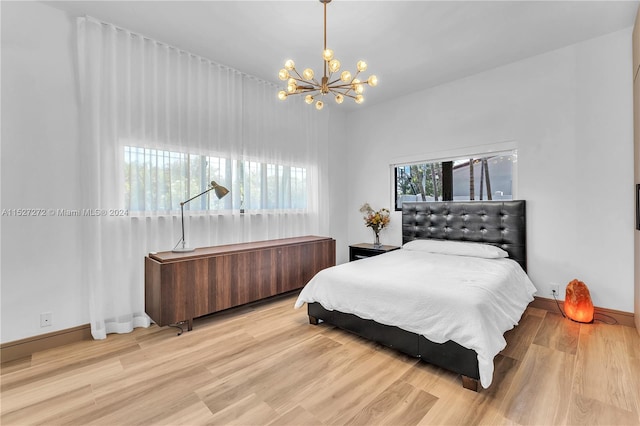 bedroom with an inviting chandelier and light hardwood / wood-style flooring