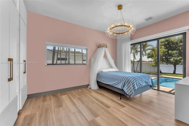 bedroom with a chandelier, light hardwood / wood-style floors, and access to outside