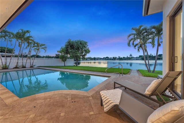 view of pool with a patio and a water view