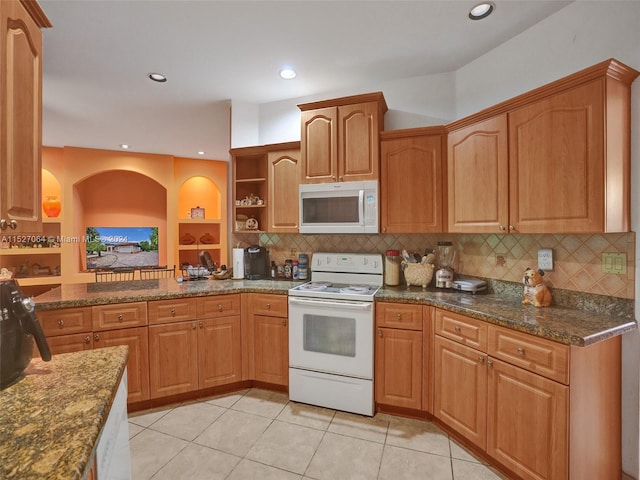 kitchen with white appliances, tasteful backsplash, dark stone countertops, and light tile floors