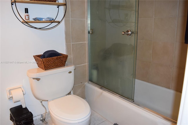 bathroom featuring shower / bath combination with glass door, toilet, and tile floors