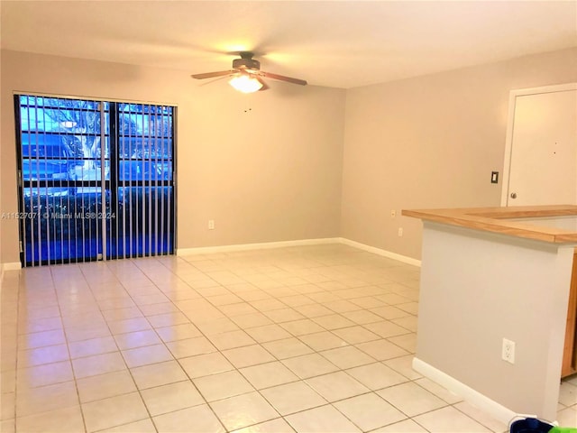 tiled empty room featuring ceiling fan