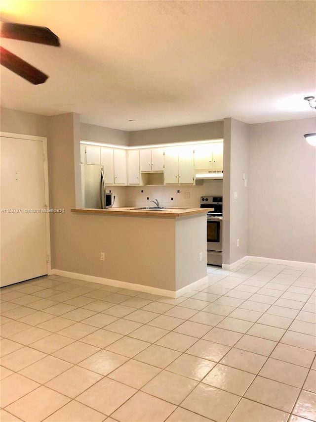 kitchen featuring stainless steel fridge, ceiling fan, white cabinets, light tile flooring, and range