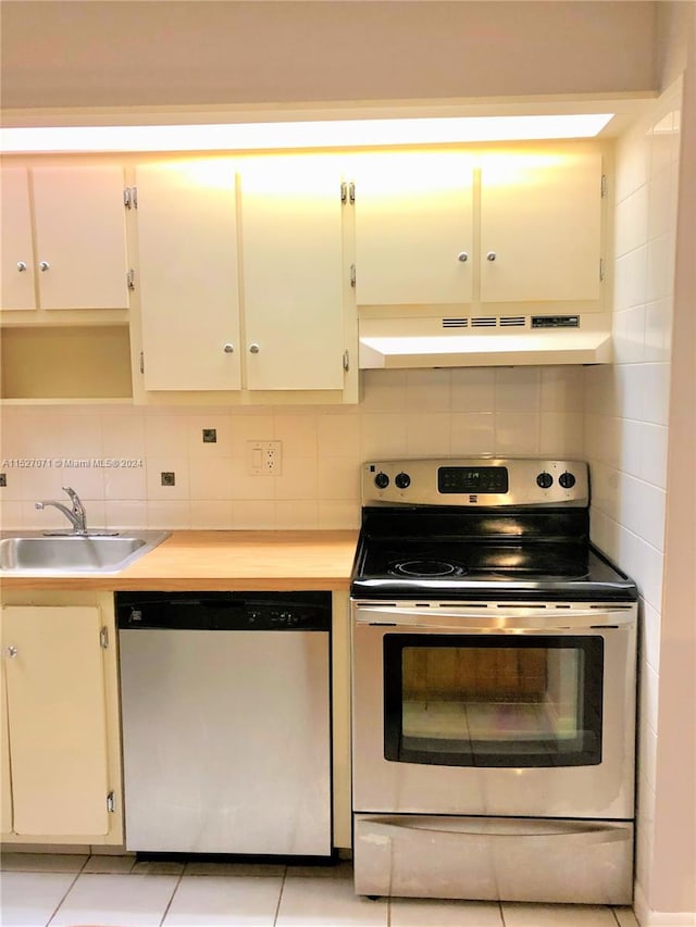 kitchen with premium range hood, stainless steel appliances, white cabinetry, backsplash, and sink