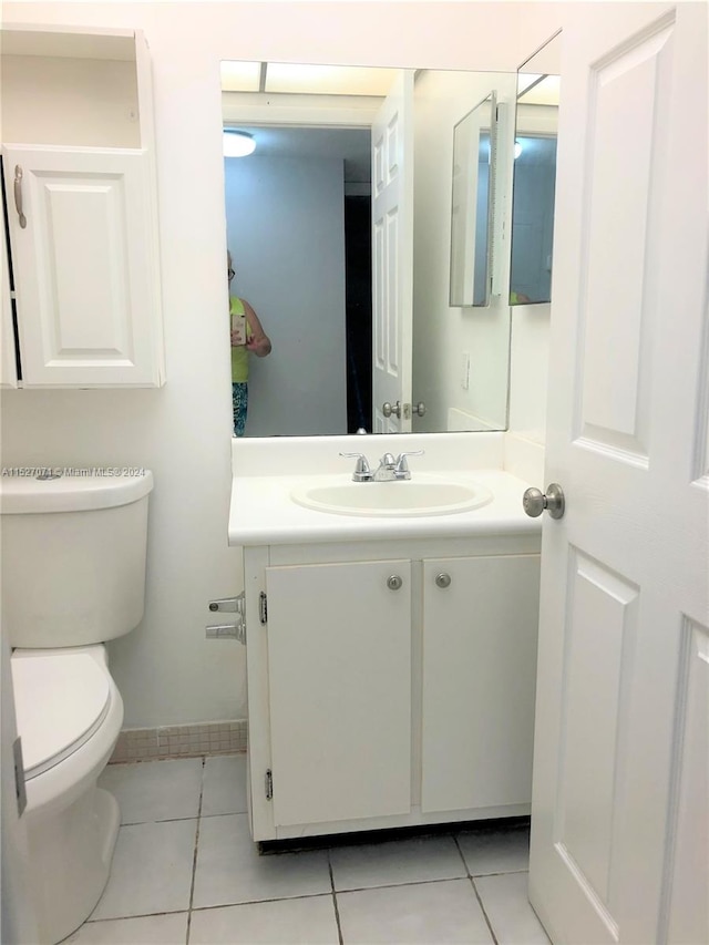 bathroom featuring vanity, tile flooring, and toilet