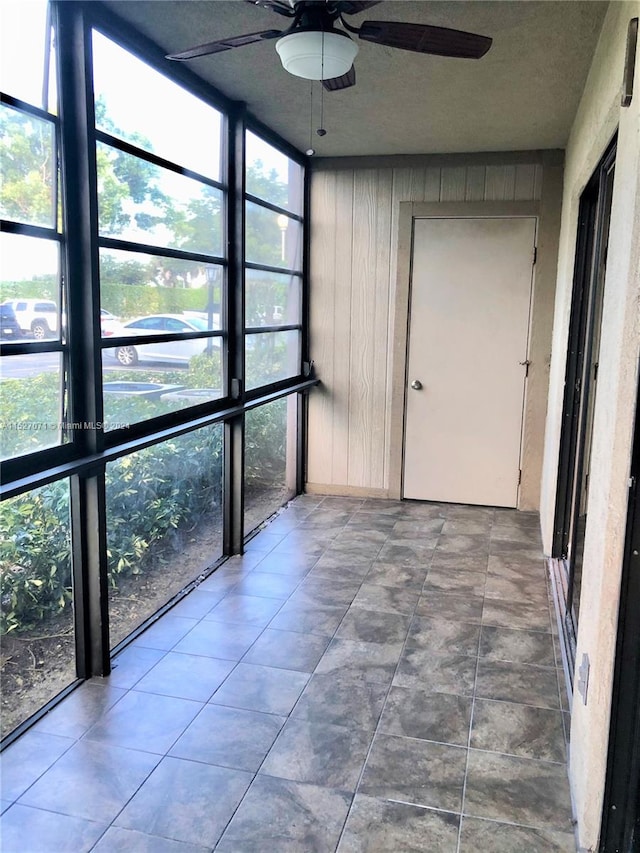 unfurnished sunroom with ceiling fan and a healthy amount of sunlight