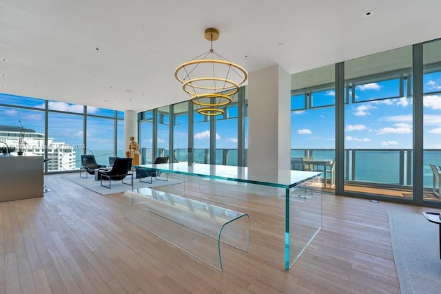 unfurnished living room with a wall of windows, an inviting chandelier, and light hardwood / wood-style floors