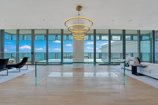 interior space featuring light wood-type flooring, expansive windows, and a chandelier